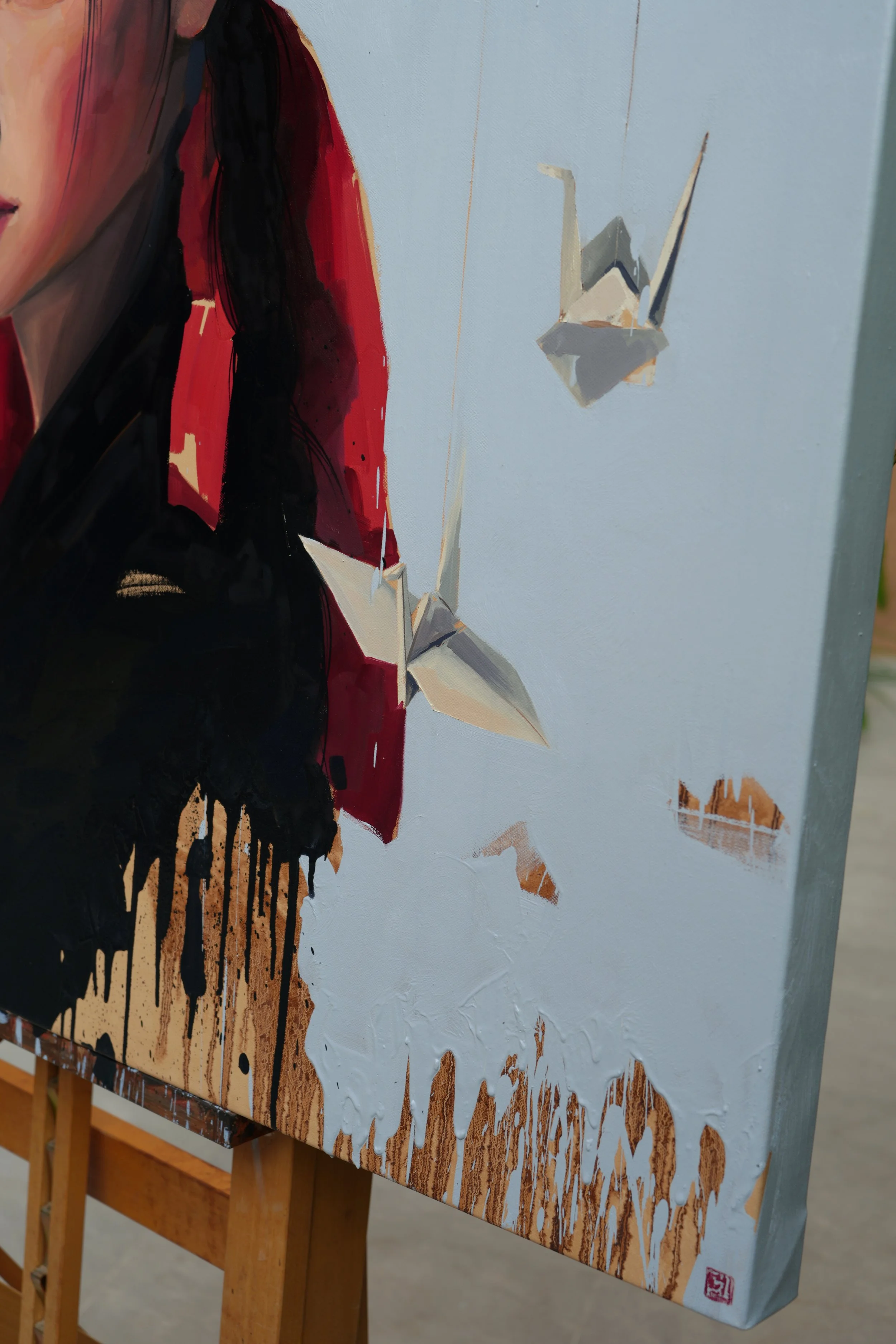 Side view of the red ribbon, black drips and a paper crane, detail of Jeopgi by Marina Ogai