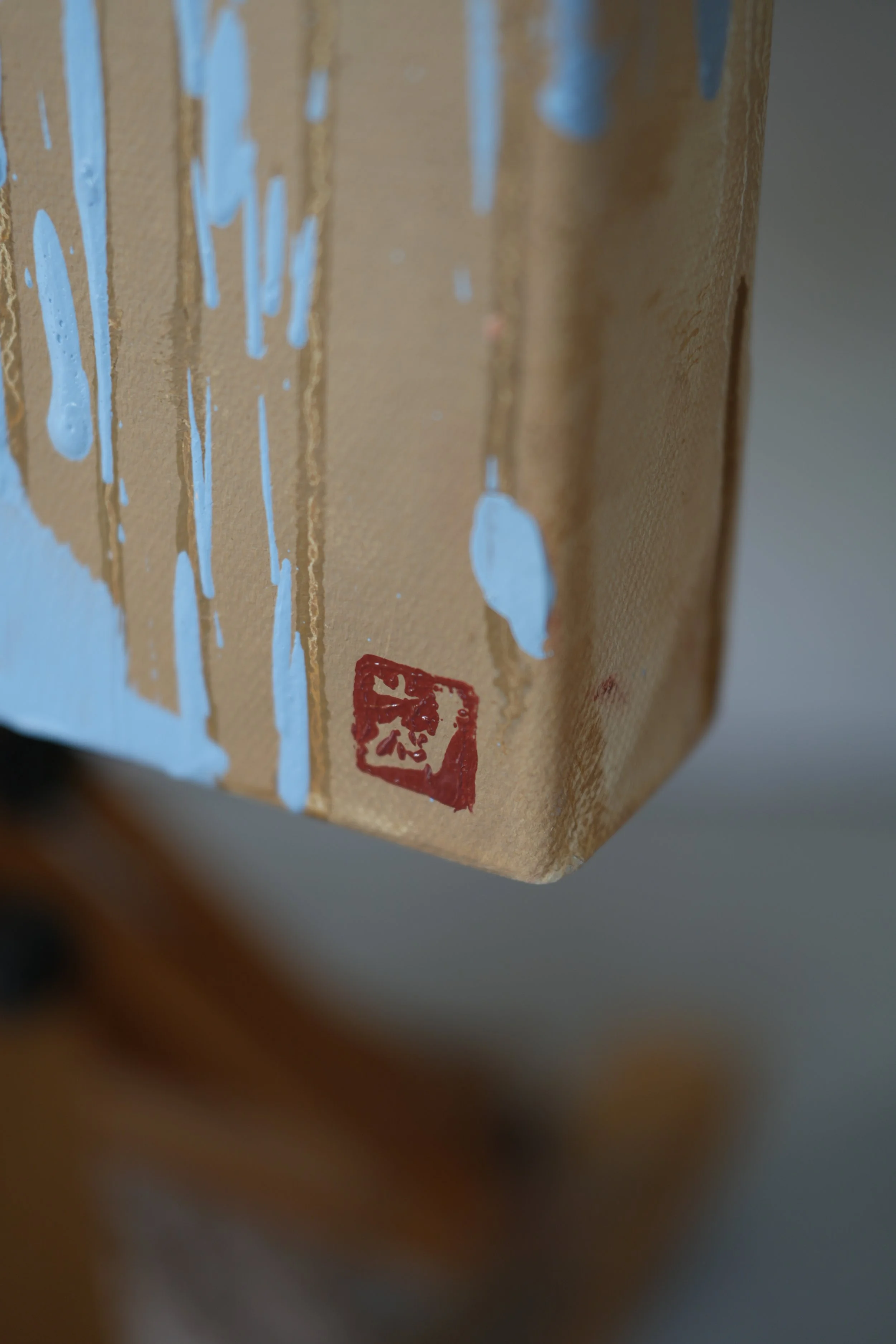 Lower corner of the canvas with the artist's red seal and ochre drips over raw linen, oil on linen, from Given