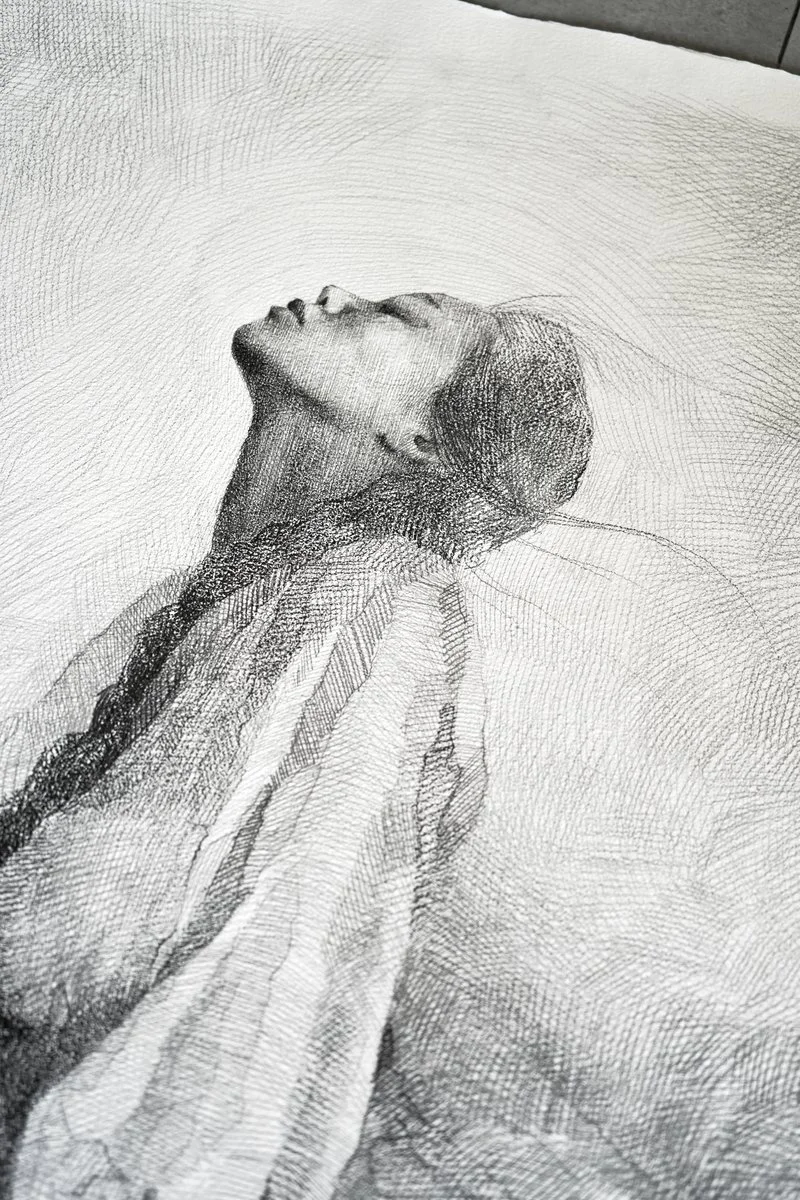 A young woman kneeling with her head tilted back and eyes closed, drapery falling from her shoulders, dense pencil hatching, from The In-Between by Marina Ogai