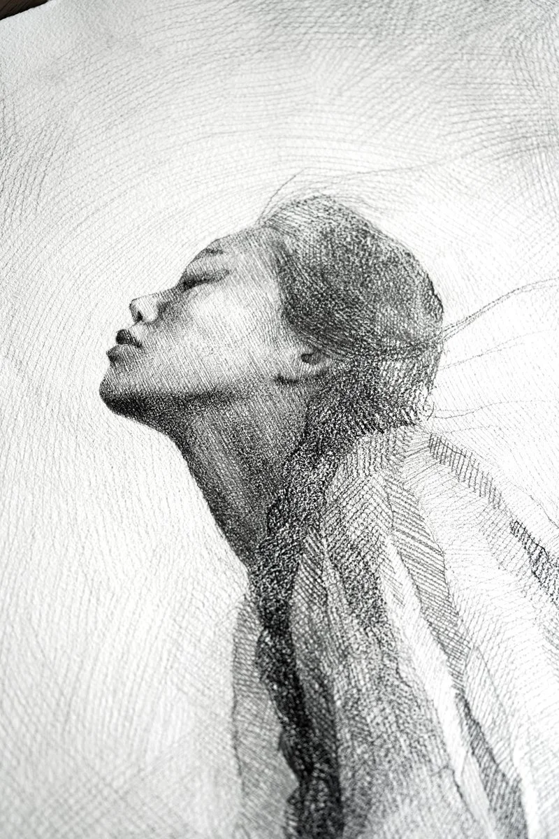 A young woman kneeling with her head tilted back and eyes closed, drapery falling from her shoulders, dense pencil hatching, from The In-Between by Marina Ogai
