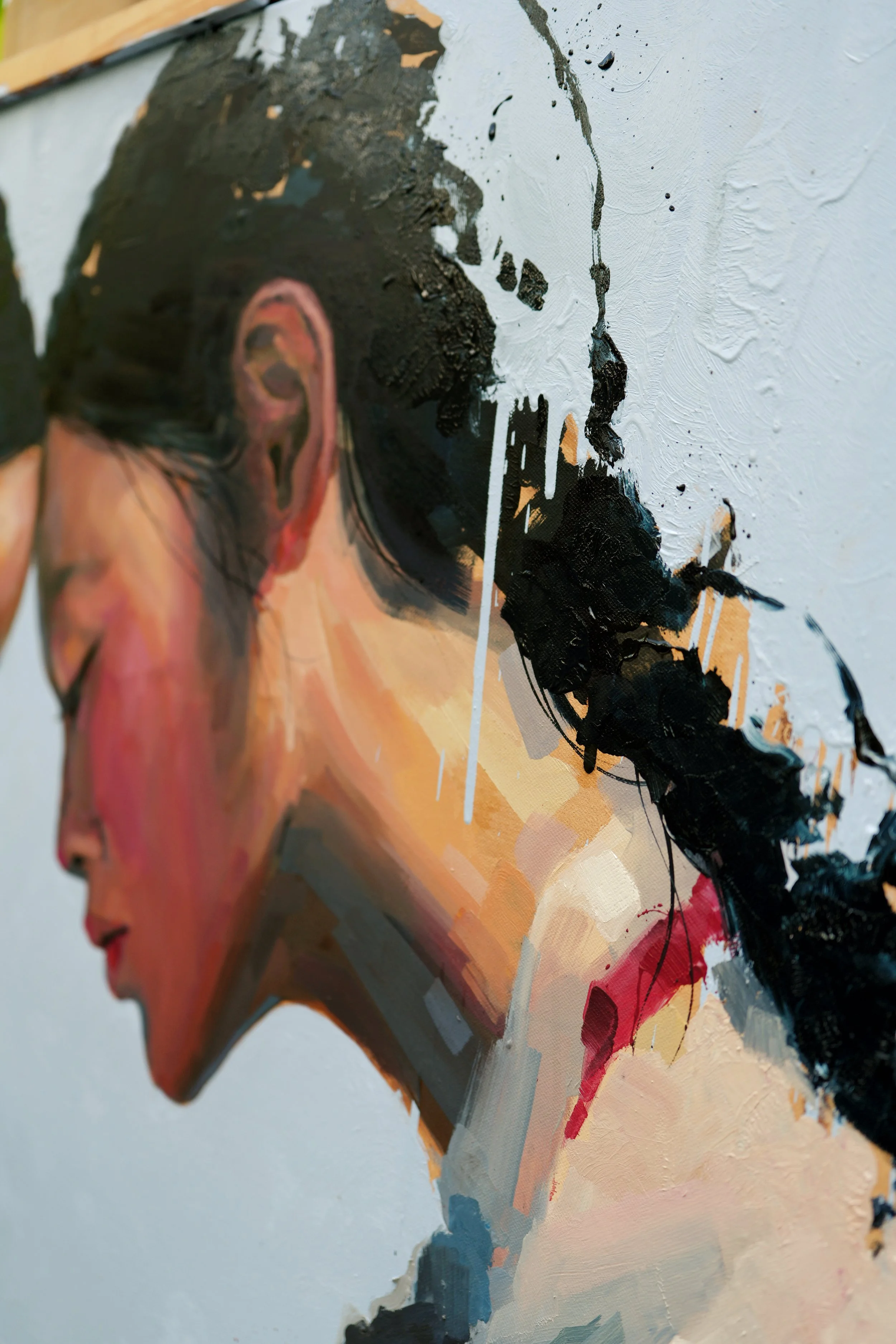 Bowed face with closed eyes, black hair in loose splashes and a paint drip, detail of The Encounter by Marina Ogai