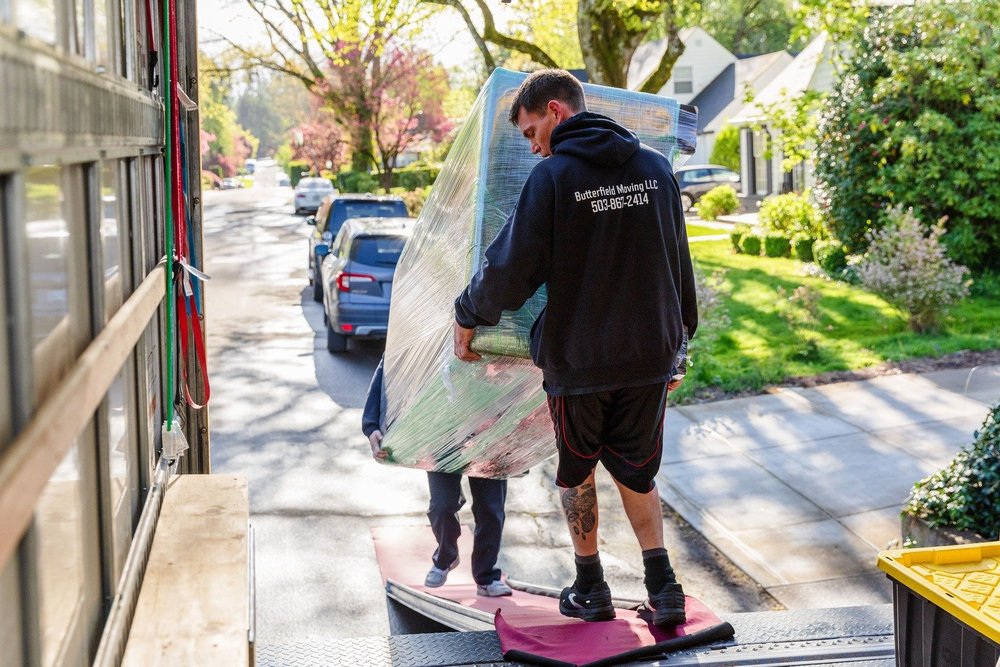 Mover carrying a wrapped piece up the truck ramp on a residential street, move in McMinnville