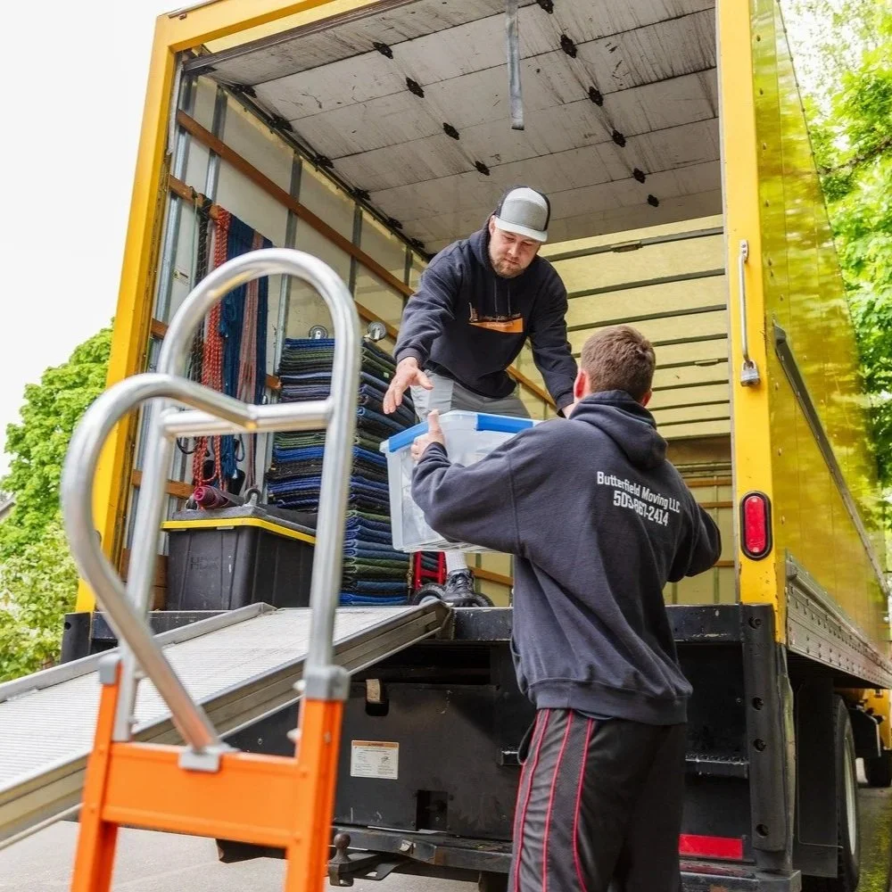 Portland movers load belongings into moving truck during residential relocation, illustrating seasonal moving demand, scheduling challenges, and professional moving services.