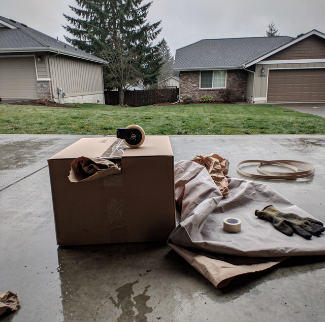 moving crew wrapping glassware inside cardboard box