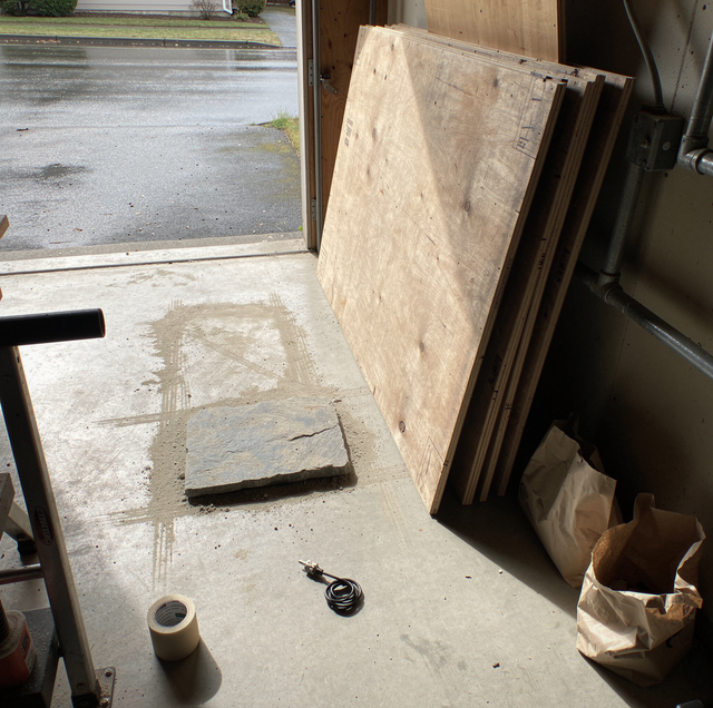Stone slab on padded sawhorses measured for plywood crate