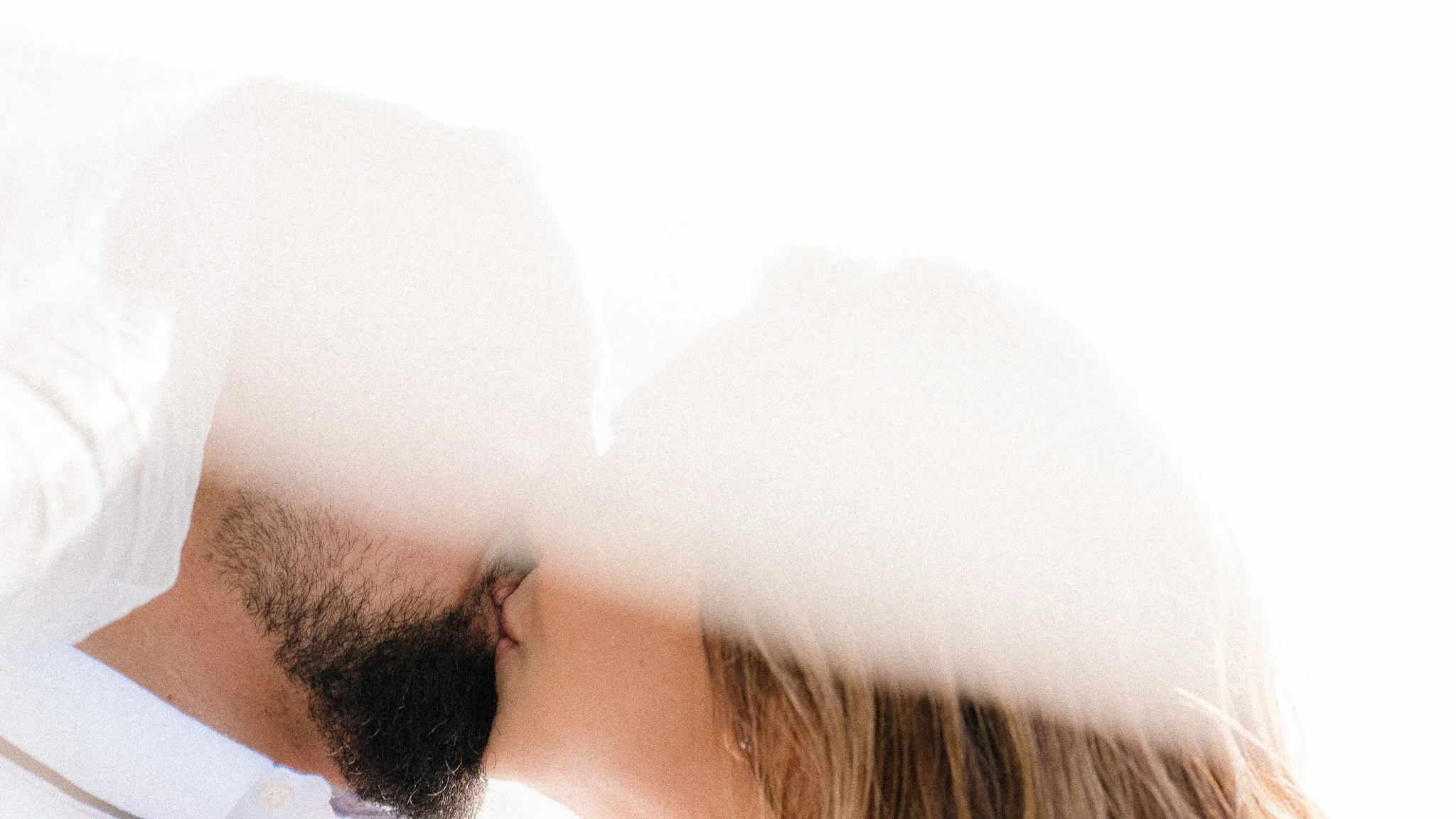 A close-up of a man and woman kissing.