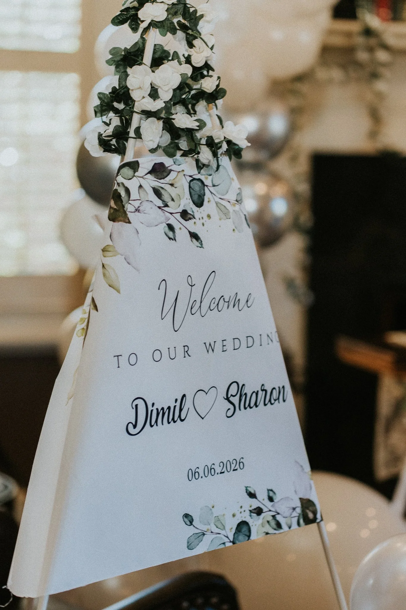 Wedding welcome sign with floral design and the names Daniel and Sharon, including the date 06.06.2026.