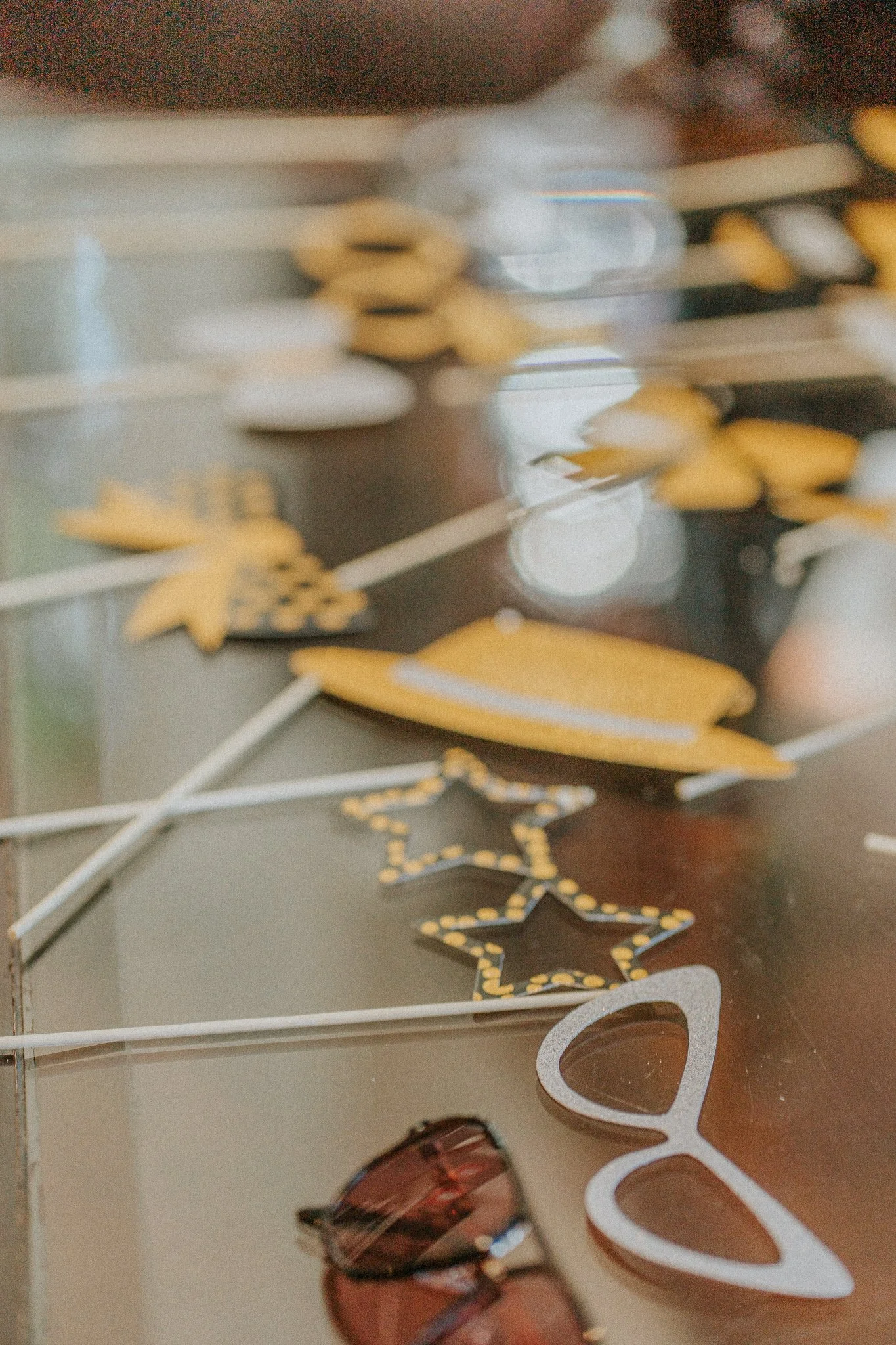 Decorative display with yellow and black star-shaped ornaments, white heart-shaped cutouts, and various reflective objects on a dark surface.