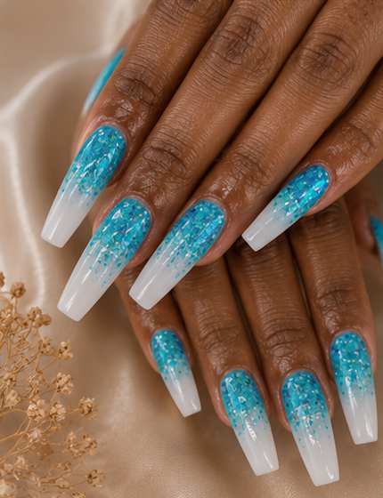 Close-up of hands with long, square-shaped nails painted with blue and white gradient nail polish and glitter accents.