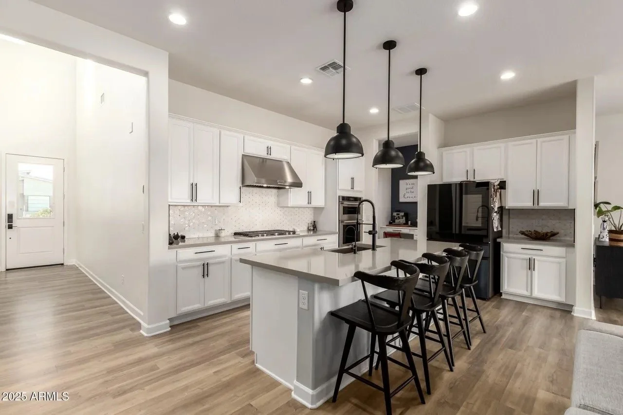 Clean kitchen with black appliances and a tidy breakfast bar