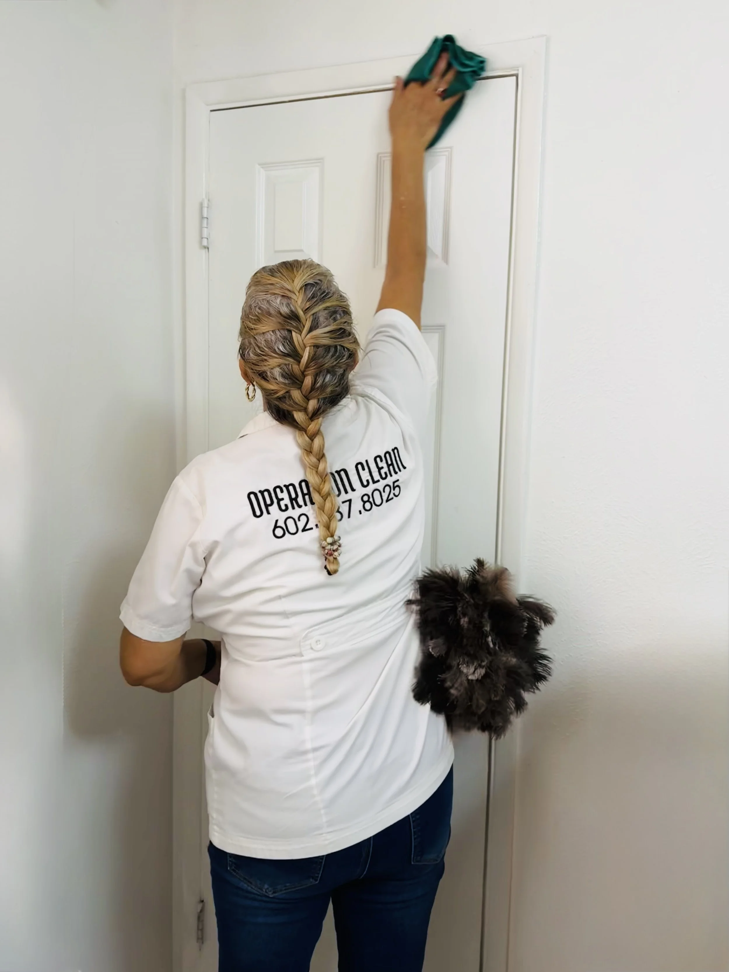 Cleaner wiping a door during detailed residential cleaning