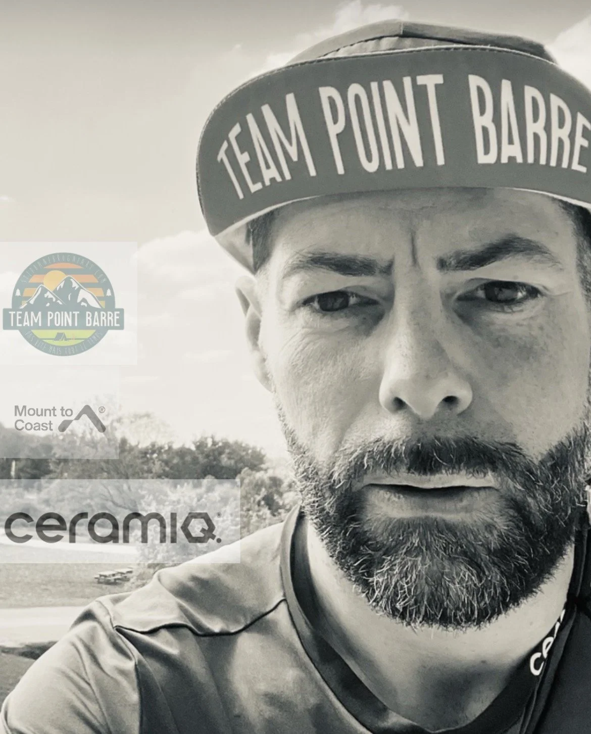 Un homme avec une barbe porte une casquette avec l'inscription "TEAM POINT BARRE". Il semble en plein air avec un ciel nuageux en arrière-plan.