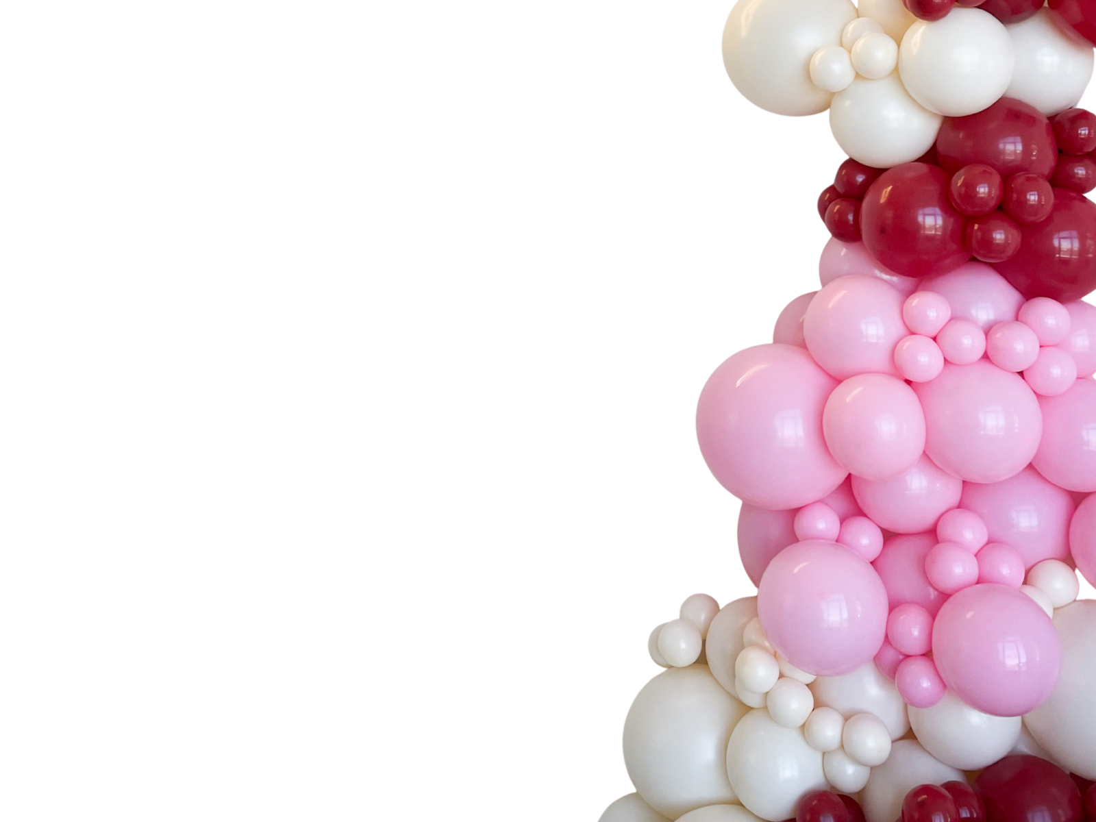 A close-up of balloons in pink, white, and red forming a cluster on the right side of the image, with the left side being plain white.
