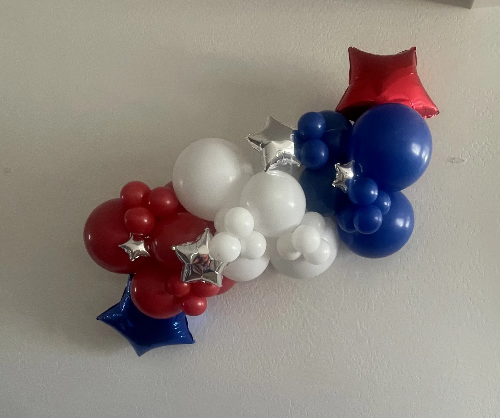 organic grab & go balloon garland  with red, white, blue, and silver star-shaped balloons. Patriotic balloons