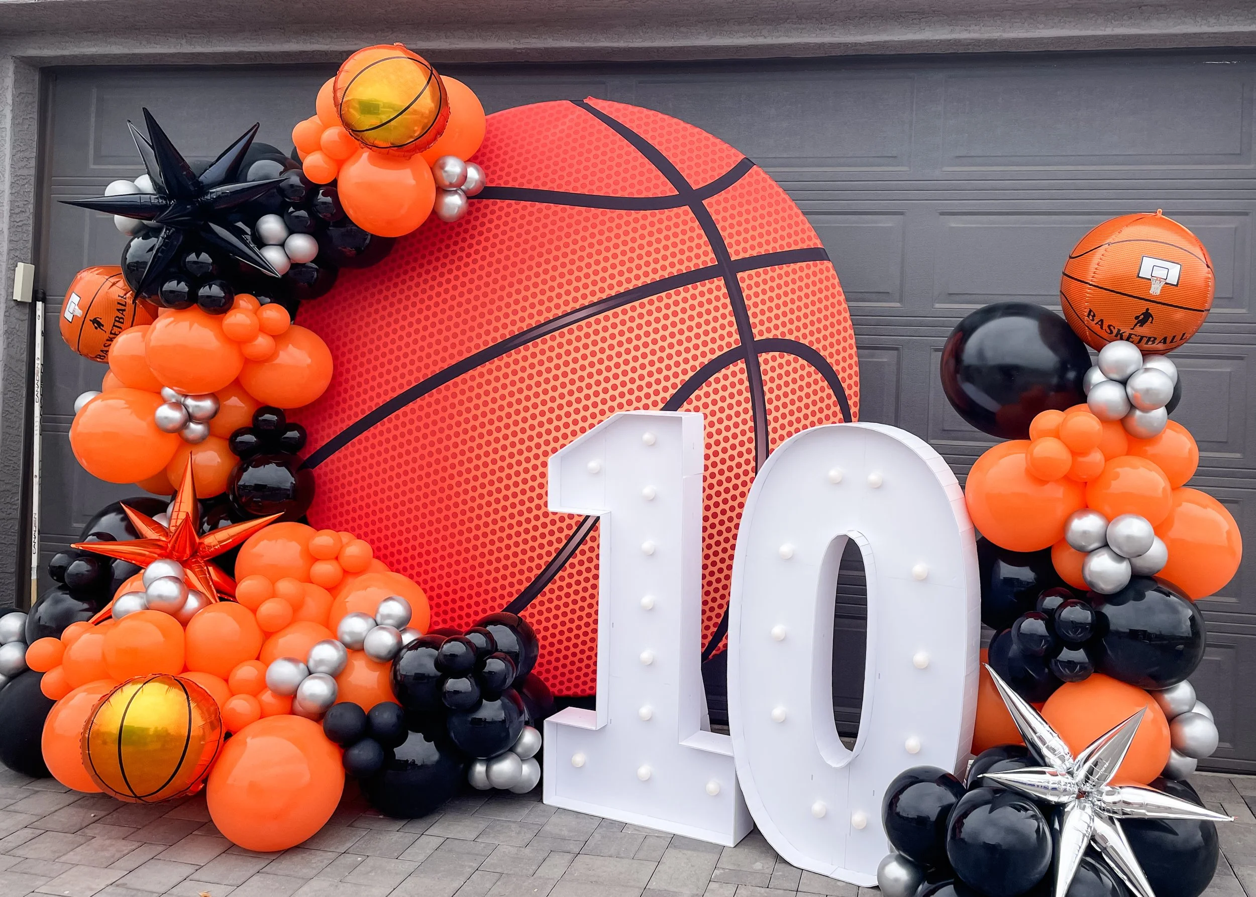 Large basketball-themed balloon display with black, orange, silver, and white balloons, including a basketball-shaped balloon with the word 'BASKETBALL' and a mini basketball graphic.