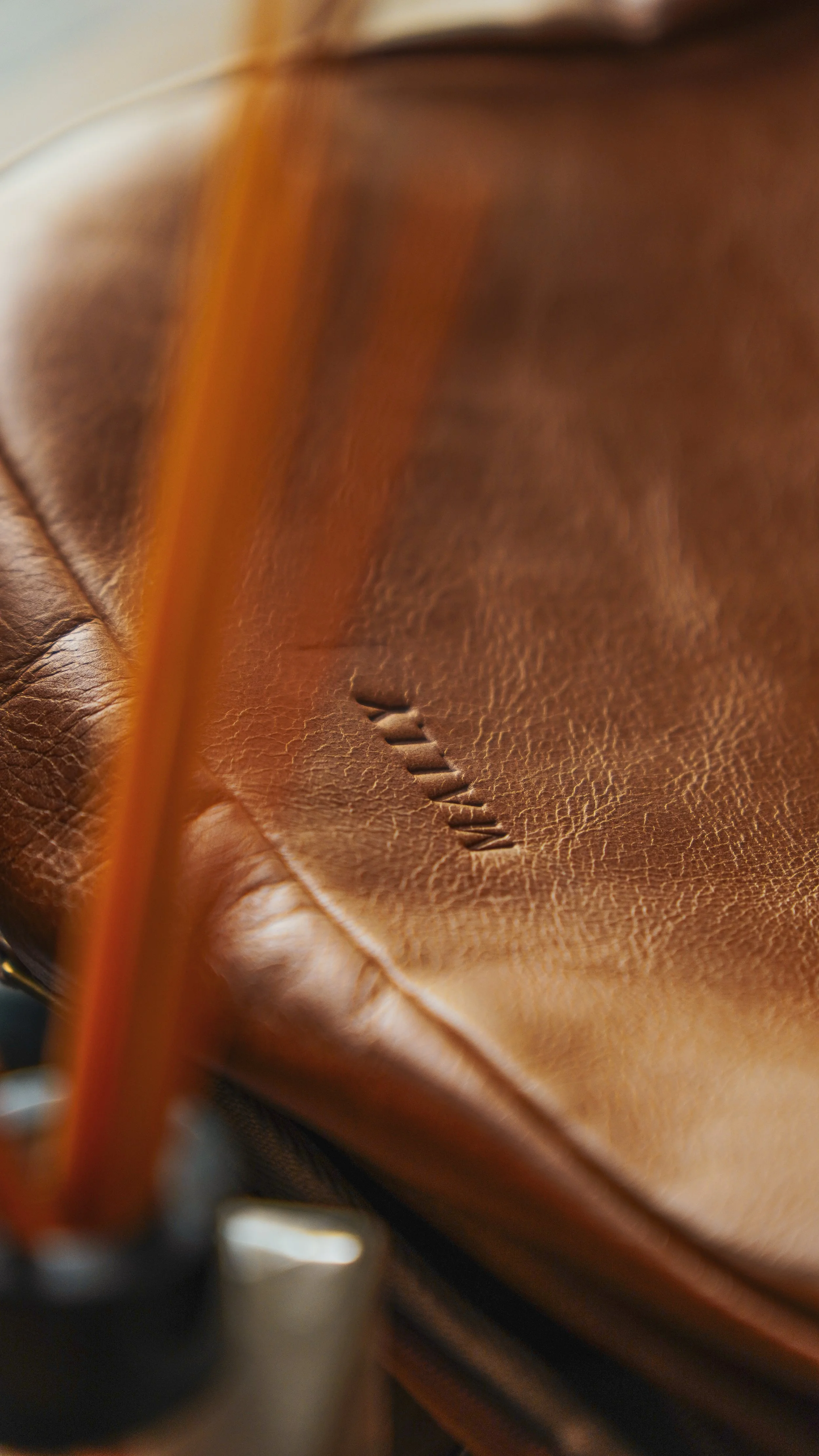 Close-up view of a brown leather baseball glove with the brand name "Wilson" embossed on it.