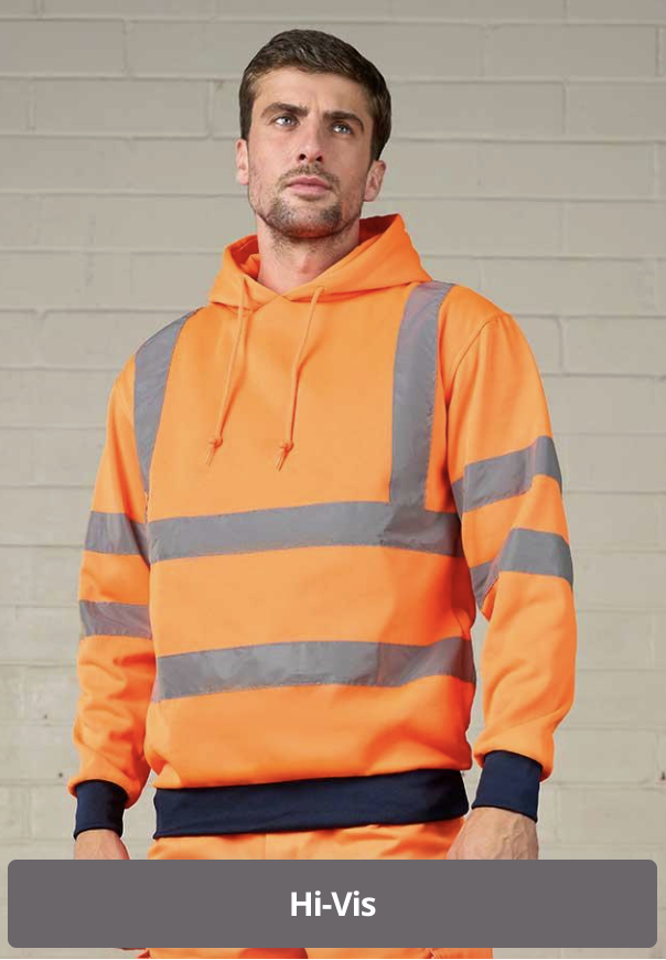 A man wearing an orange safety hoodie with reflective gray stripes standing against a light-colored brick wall.