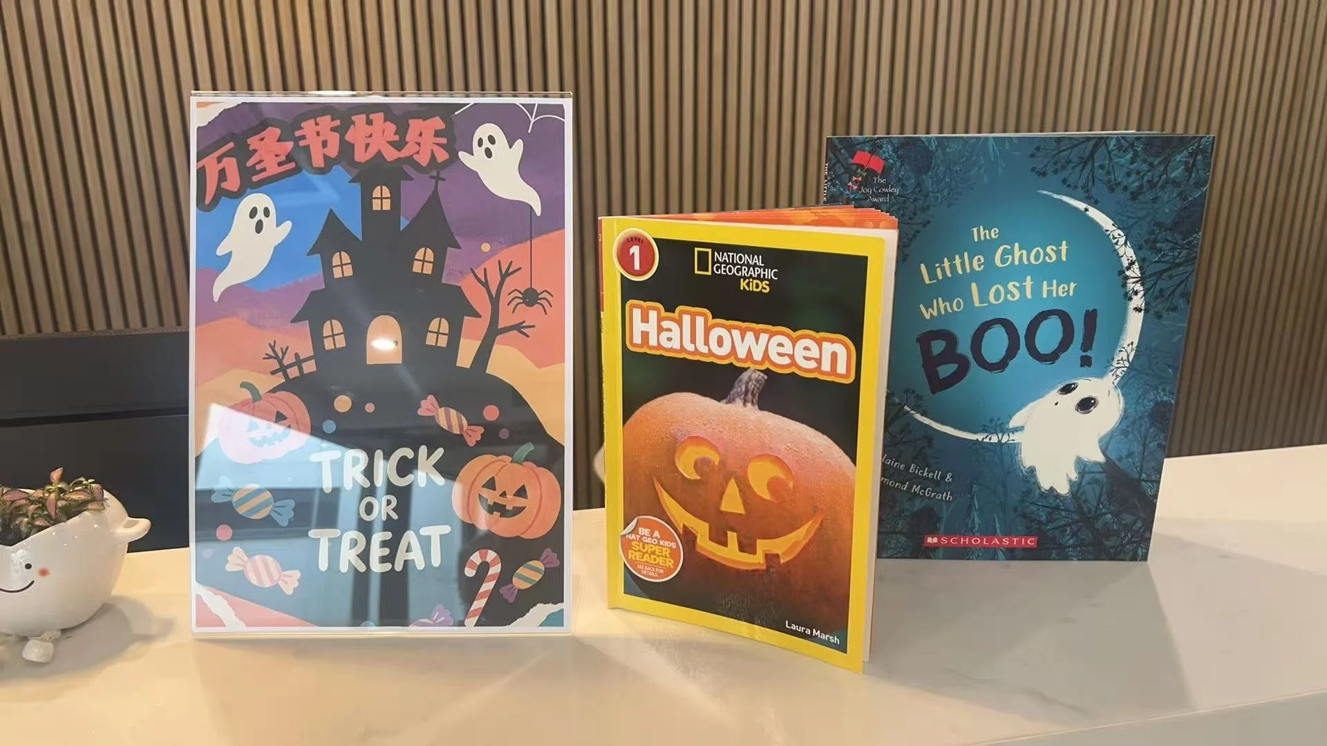 Real Mandarin's Halloween corner at reception: a colourful 万圣节快乐 (Happy Halloween) poster with ghosts, pumpkins and Trick or Treat