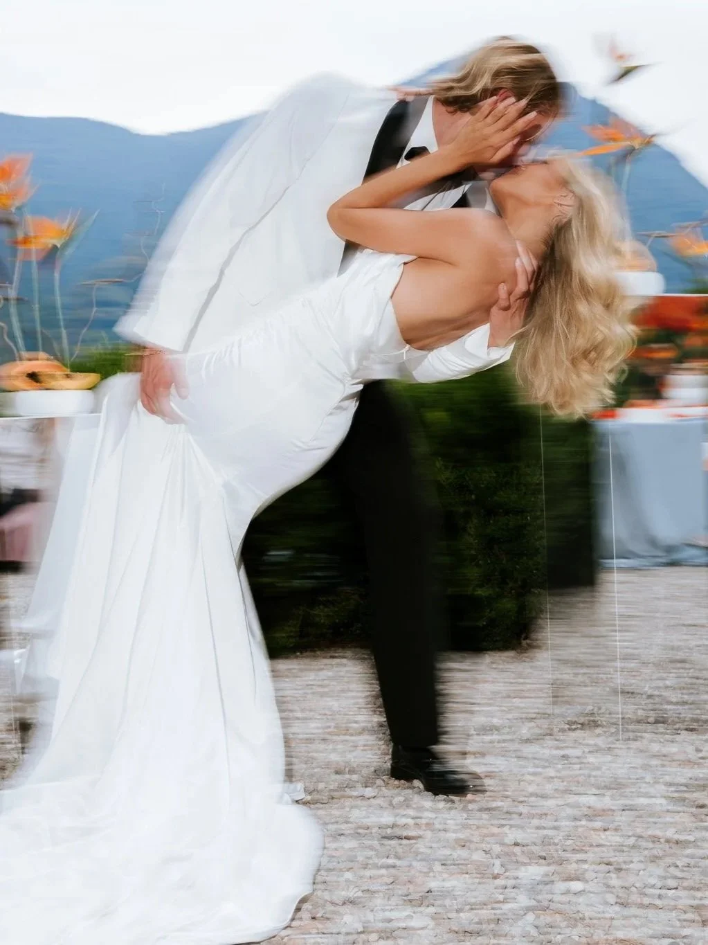 Bride and groom sharing a kiss at Villa Regina Teodolinda, Lake Como, motion blur capturing the movement, the bride in a veil and white gown.