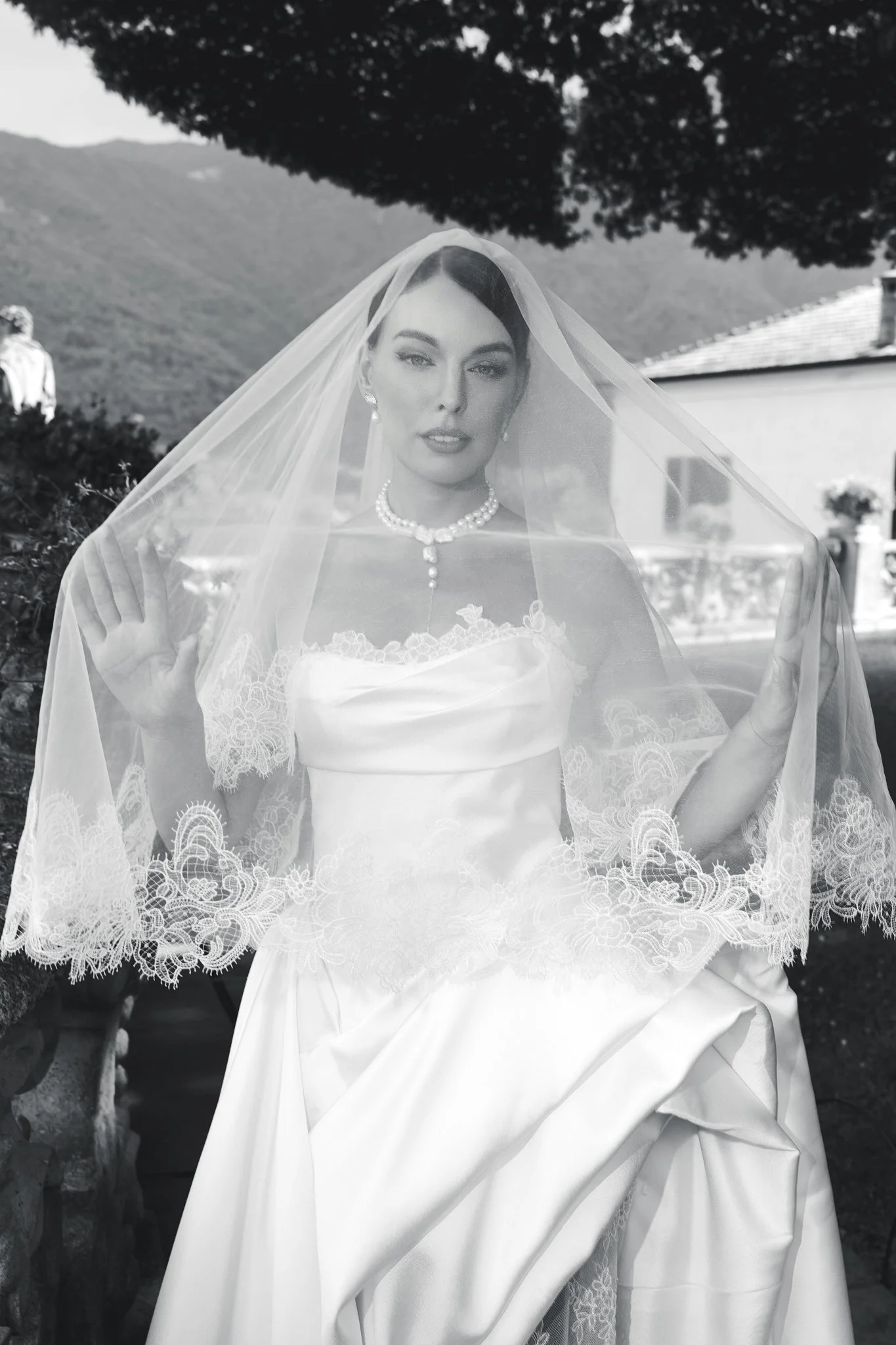 Black and white portrait of a bride in a lace wedding dress and veil at Villa del Balbianello, Lake Como.