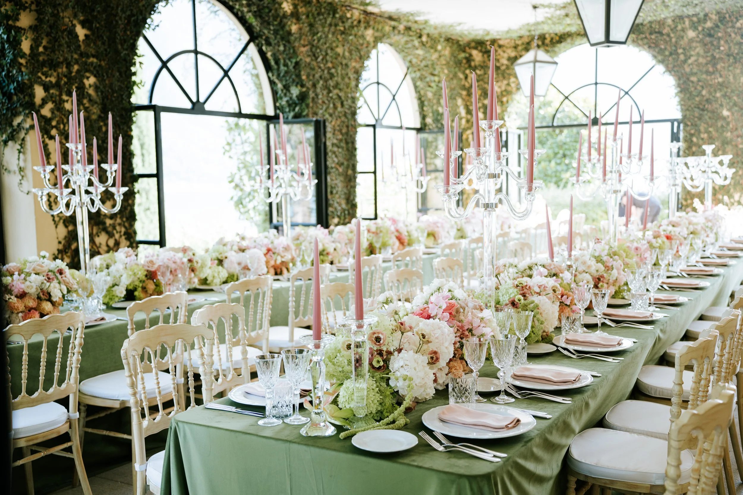 Long reception table with floral arrangements and crystal candelabras under the loggia at Villa del Balbianello, Lake Como.