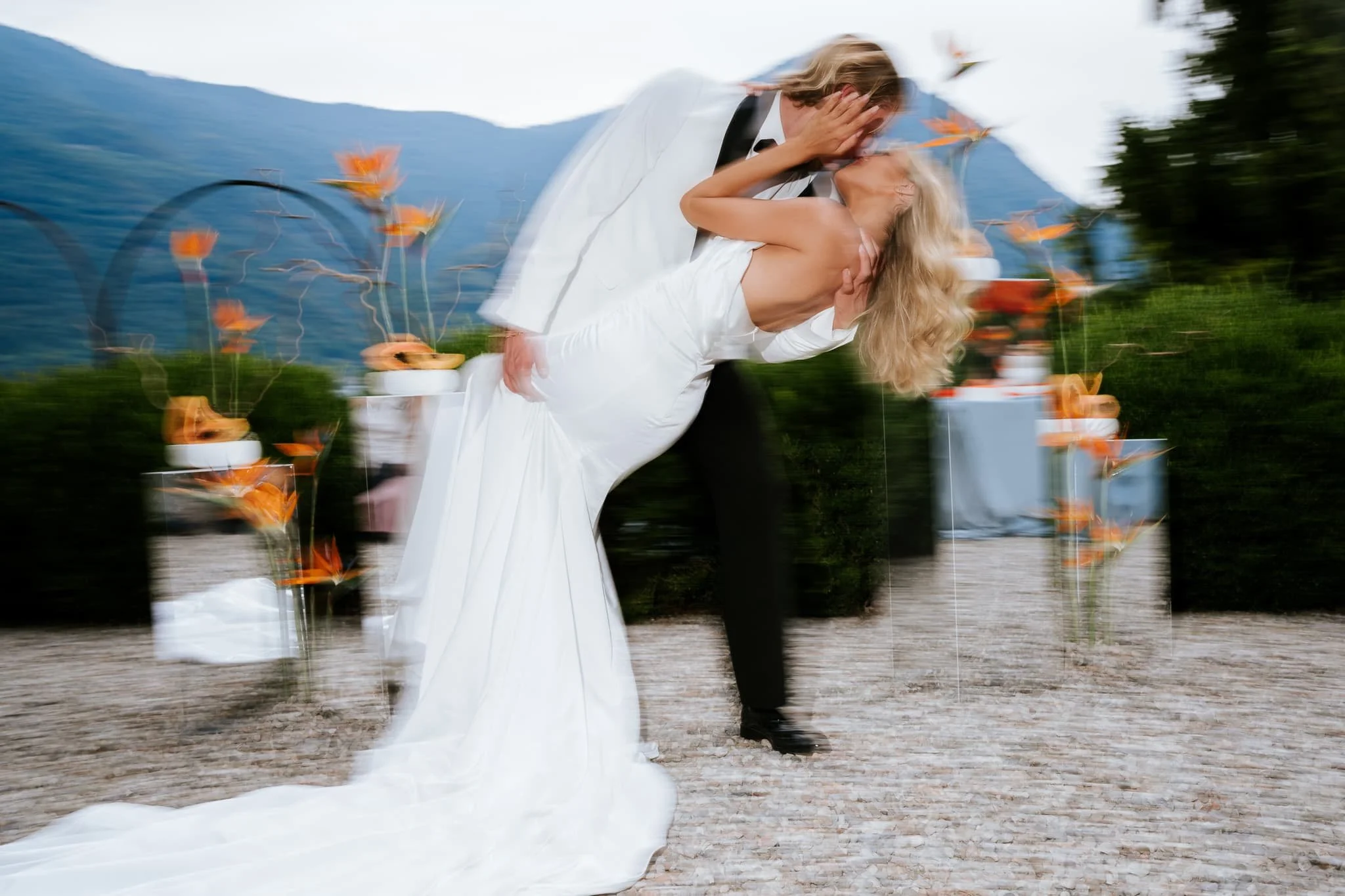 Bride and groom in a film motion documentary style portrait of a kiss with lake como in the background