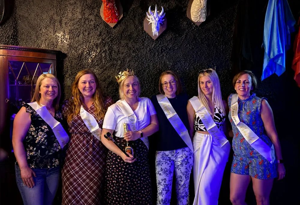 Hen party in Team Bride sashes celebrating after an escape room at Escape London