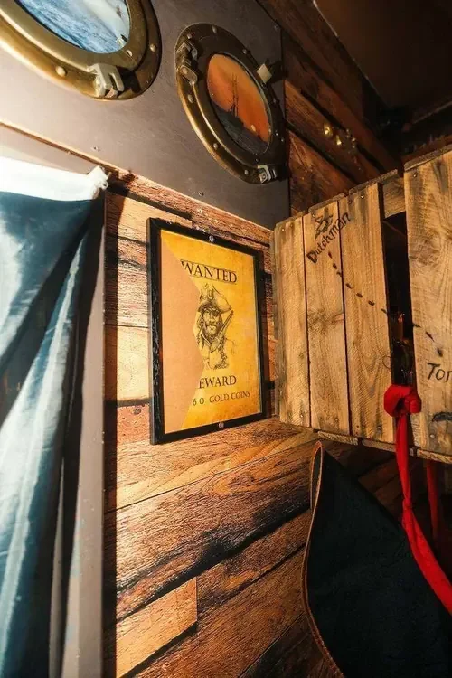 The Jolly Roger flag and a locked sea chest below deck in Pirates’ Fortune — Escape London Whitechapel