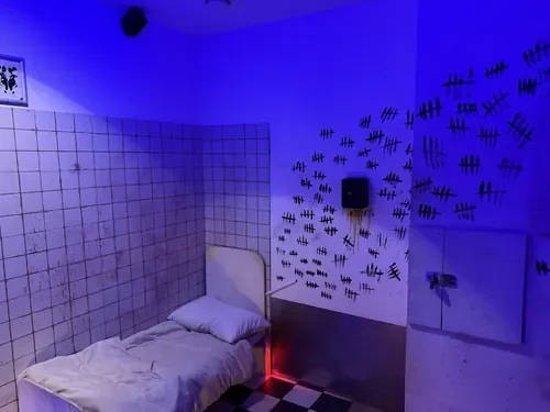 A patient bed and tally-marked walls in Echoes of Madness — Escape London Islington