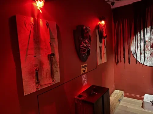 Mr. Hunt’s red-lit trophy wall in Echoes of Madness — Escape London Islington