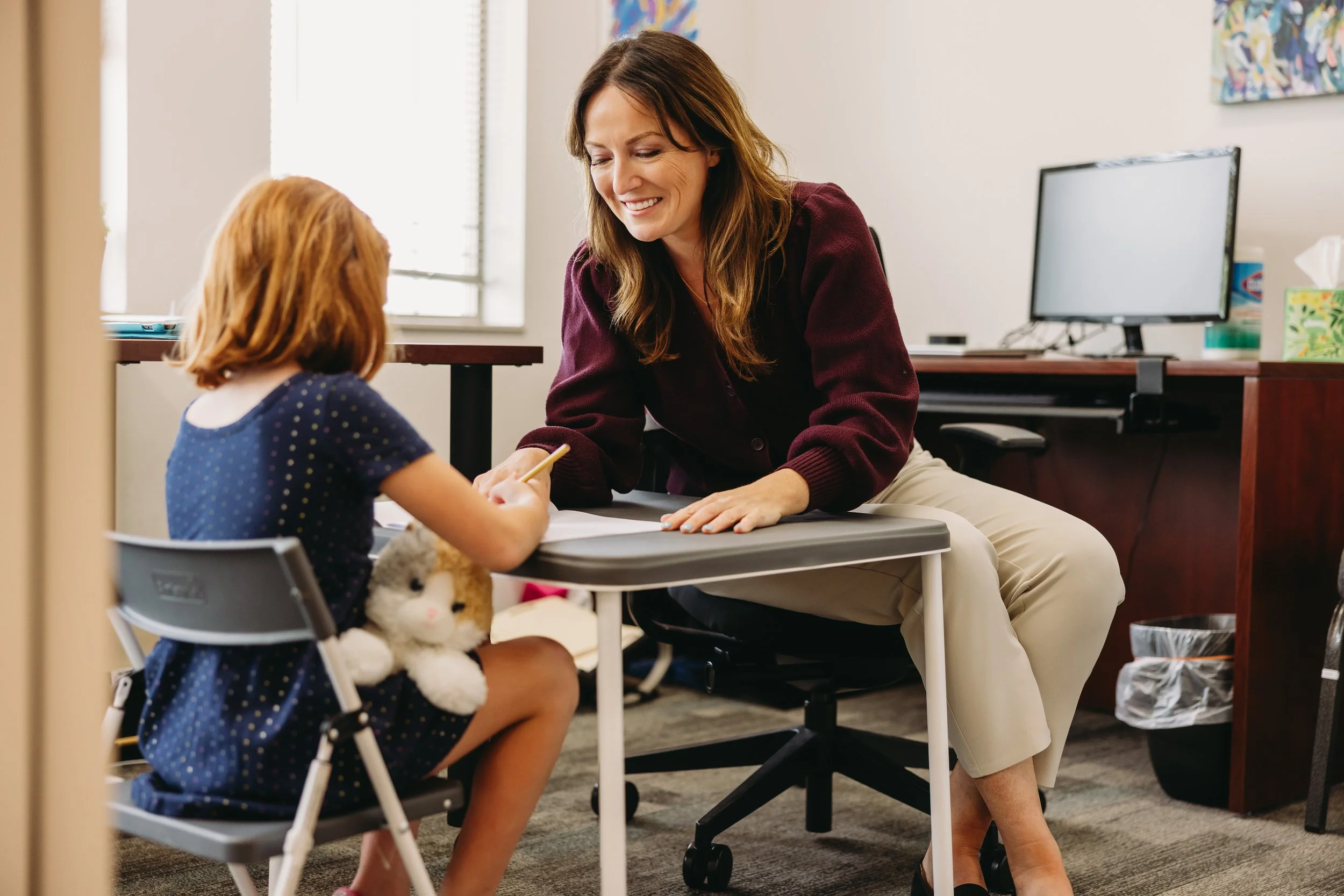 Pediatric neuropsychology evaluation in a private practice setting, with a clinician working one-on-one with a child during a developmental assessment.