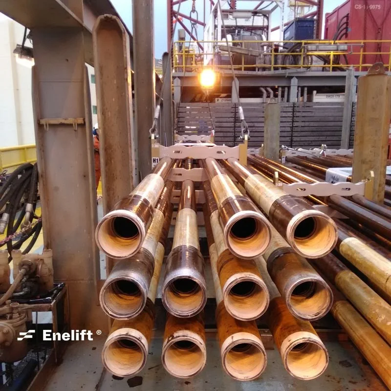 Several large metal and rubber pipes arranged in parallel on an industrial drilling rig or machinery at an oil or gas extraction site.