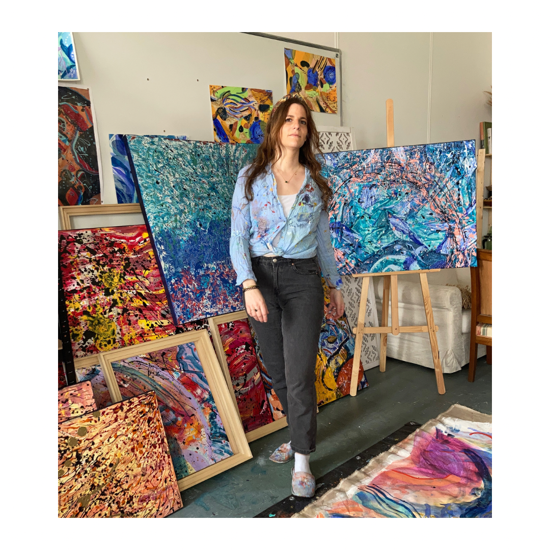 Artiste dans son atelier entourée de grandes toiles abstraites