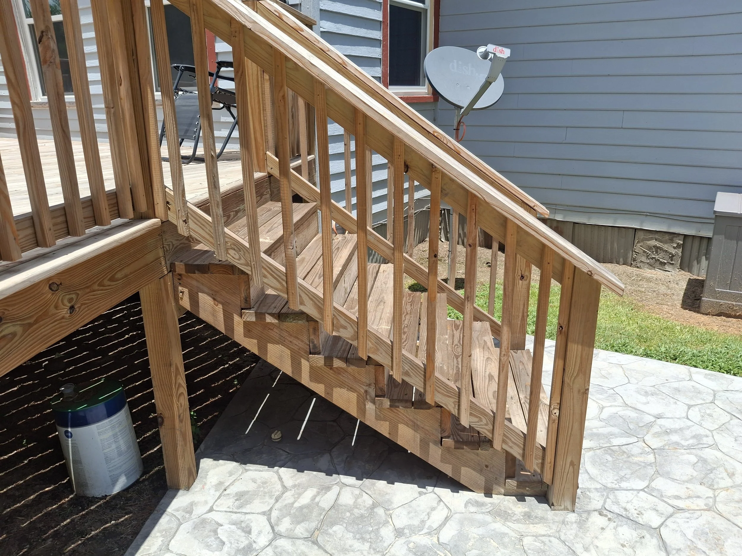 Wood deck stairs and railing built for backyard swimming pool access.