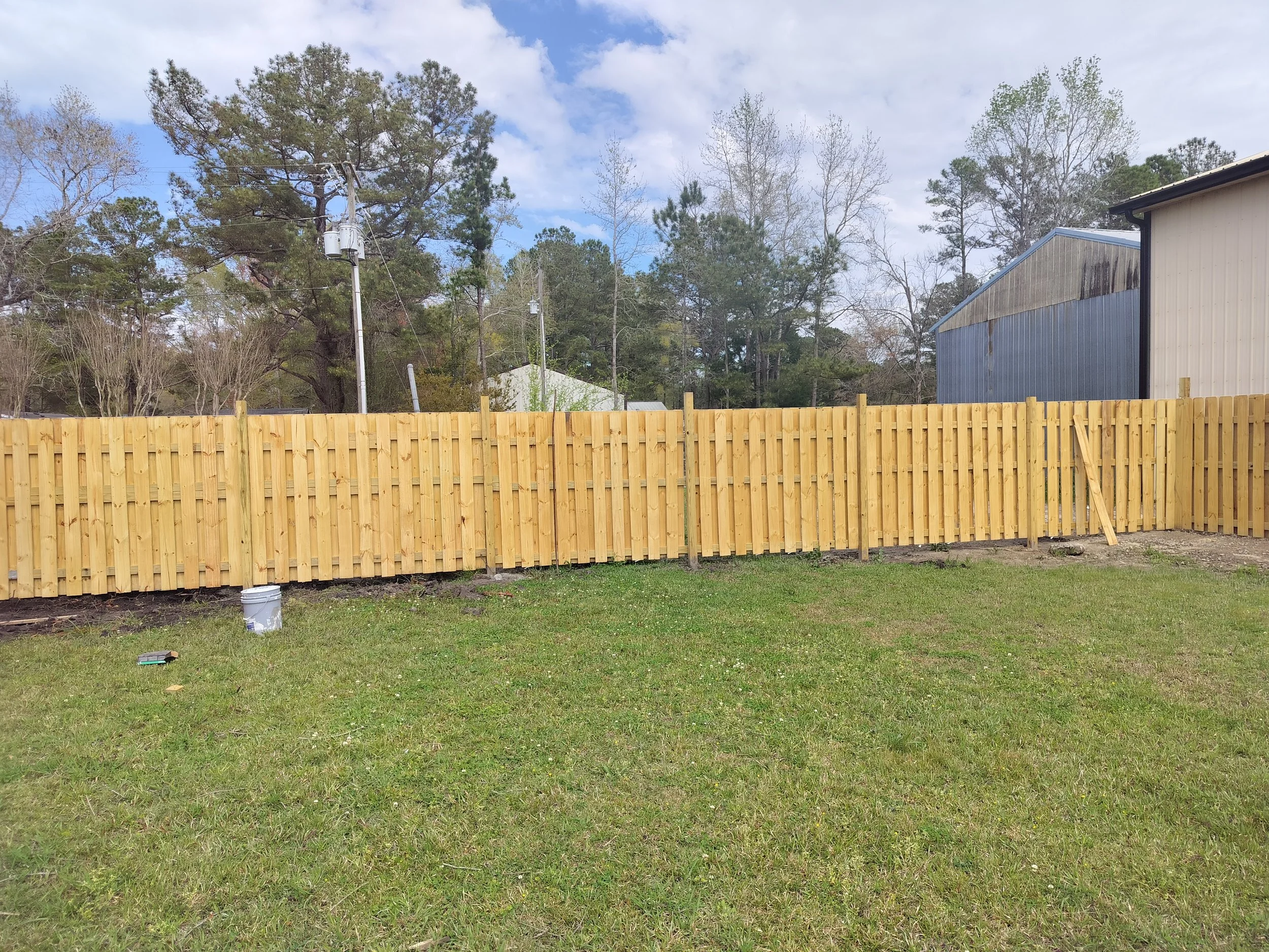 Backyard with wooden privacy fence and open lawn area.