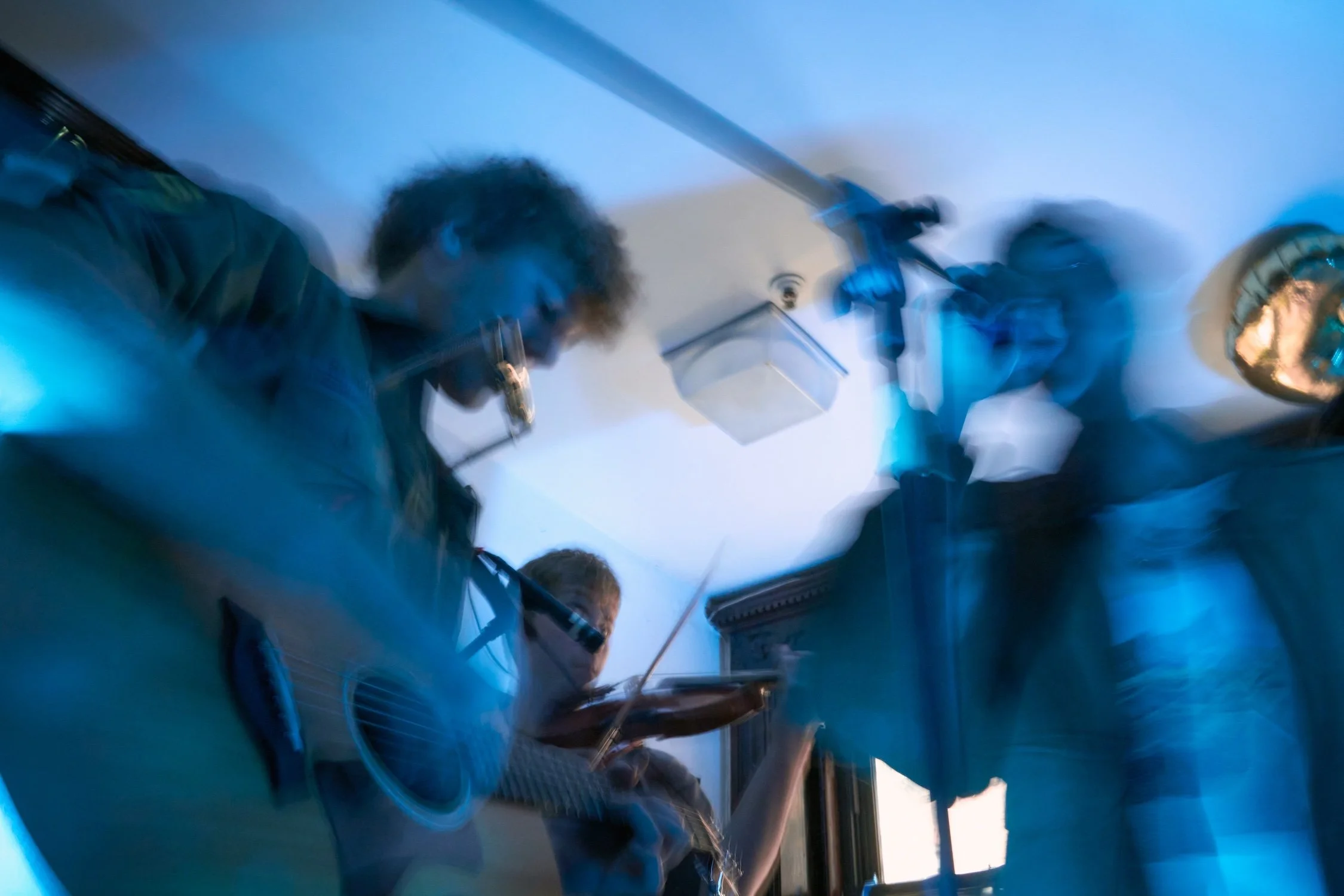 A group of people, likely in a medical or scientific setting, are gathered around a display or equipment. They appear to be focused and engaged in an activity, with some pointing or discussing. The environment has a clinical or technical feel, with c