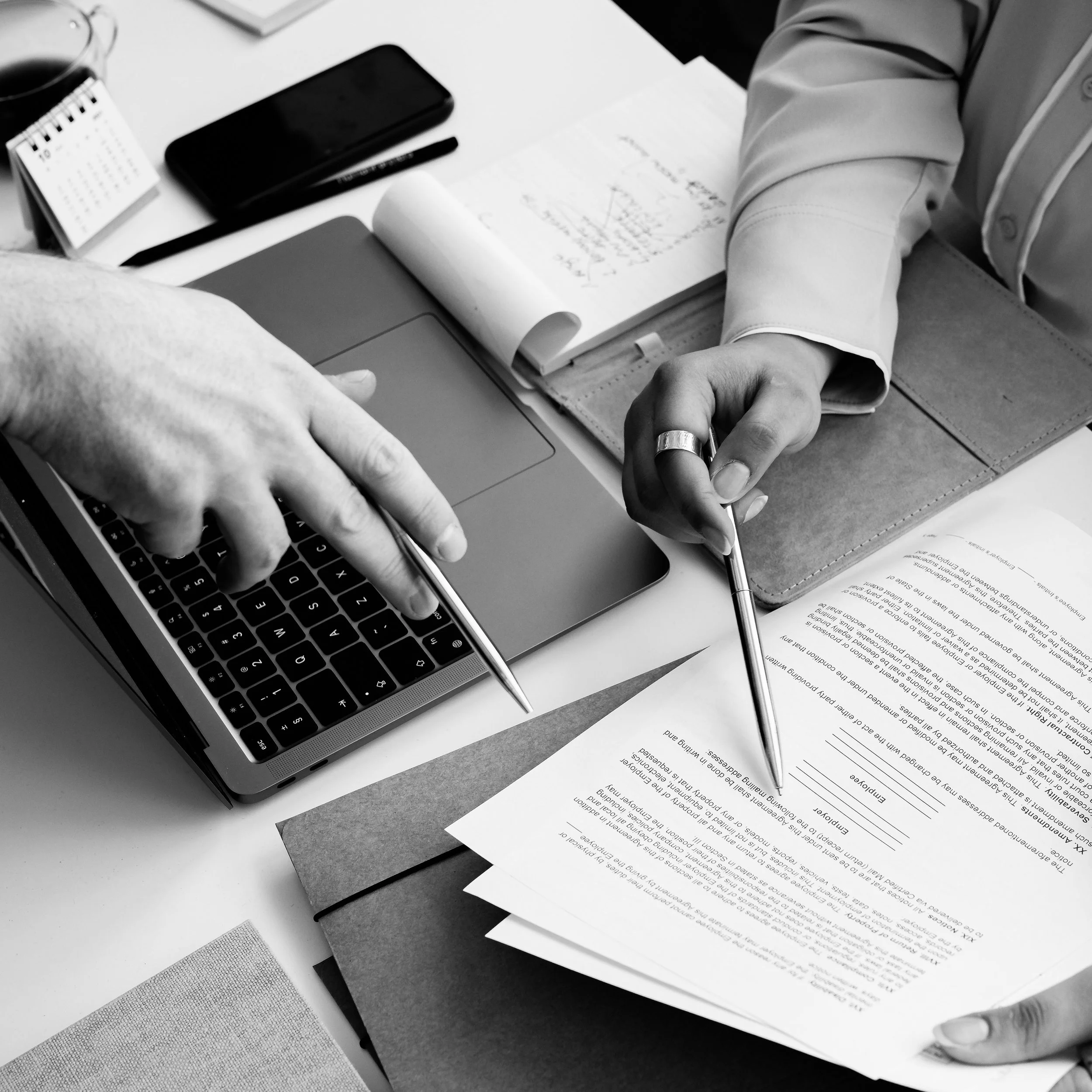 Deux personnes discutent autour d'un permis de construire refusé, en essayant de trouver une solution pour qu'il soit accepté.