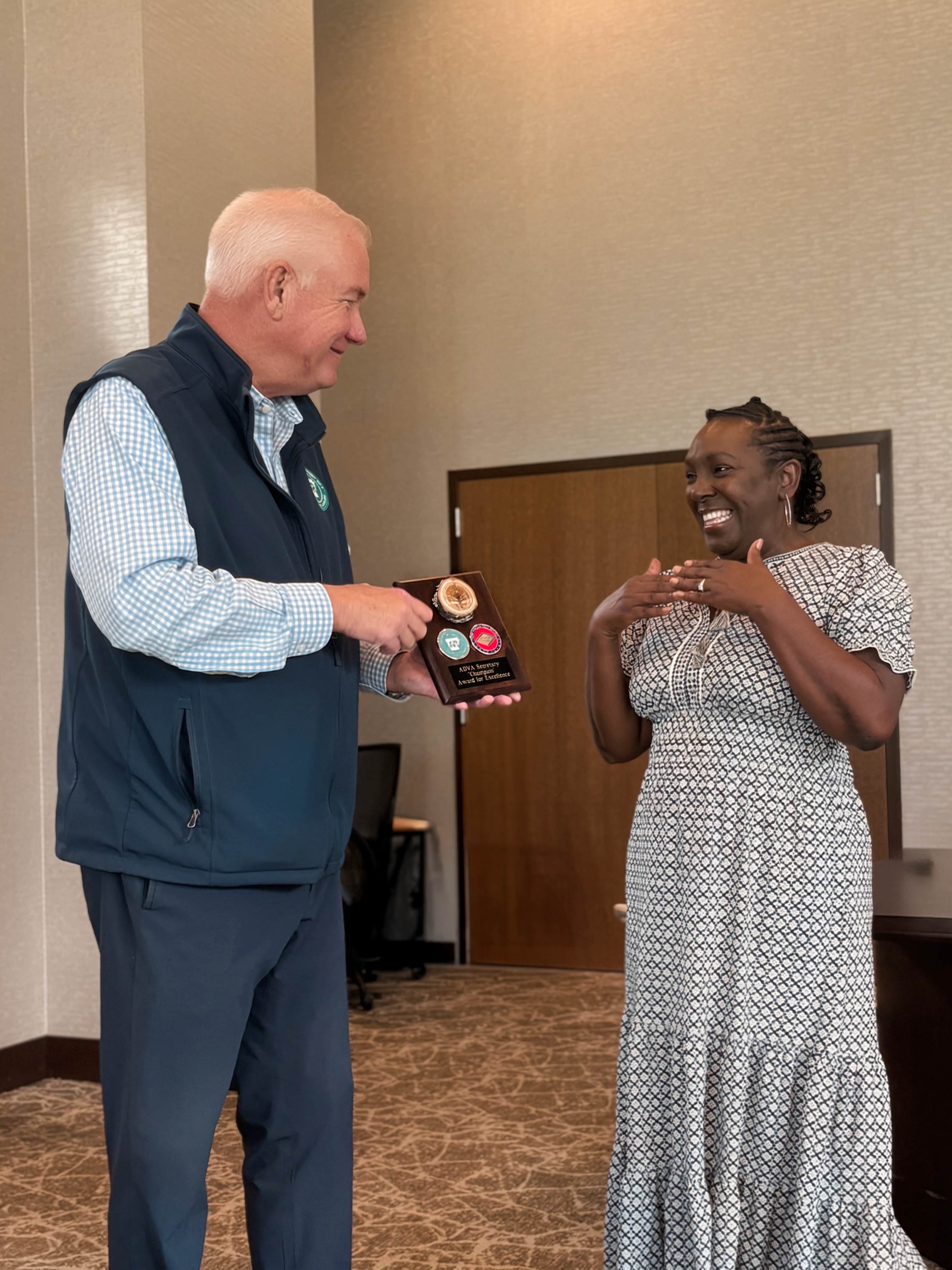 Secretary Ator presenting a Champion Award to Riva Miller.