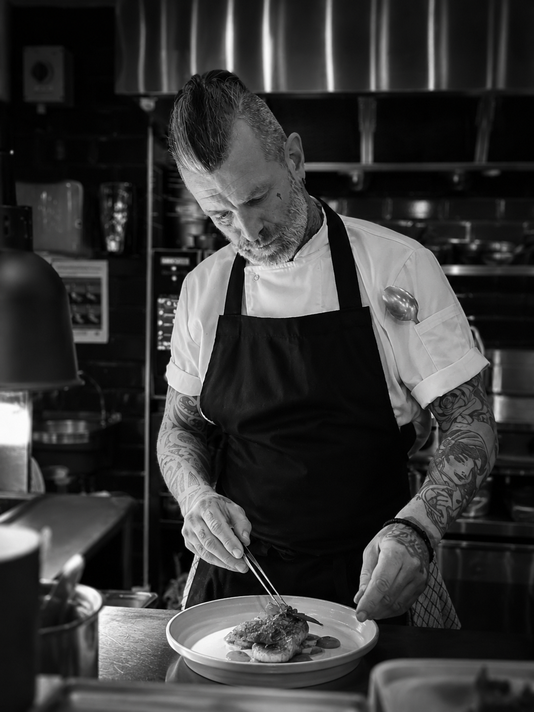 Ross McGregor, head chef at Society, plating a dish in the restaurant kitchen.