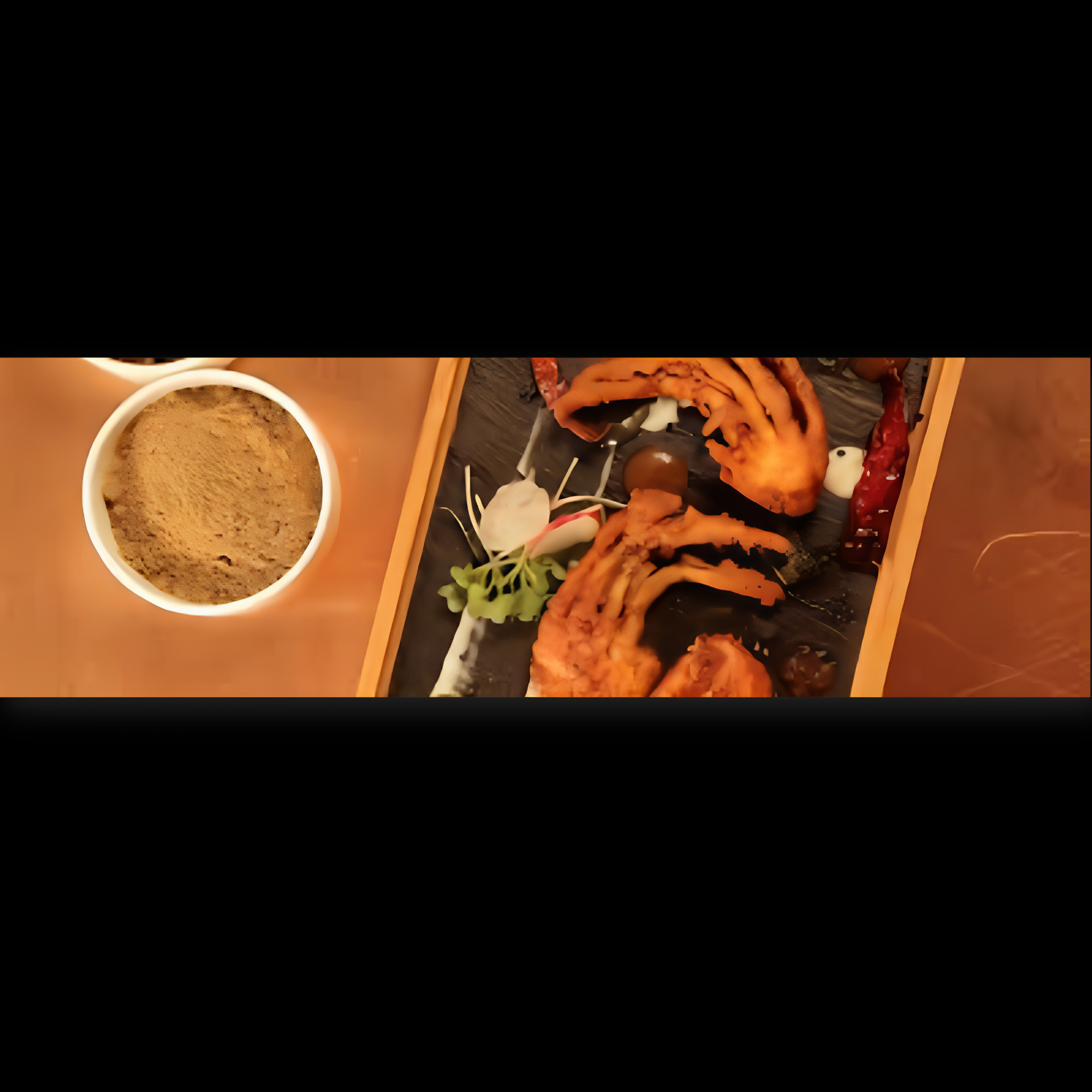Close-up of a cup of coffee and a tray of assorted pastries including cookies and bread