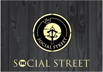 Logo for The Social Street on a dark wooden background.