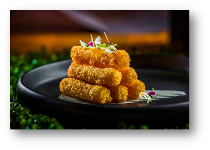 Stack of breaded and fried cheese sticks garnished with microgreens, served on a black plate.