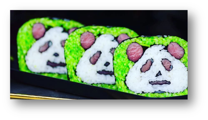 Three sushi rolls shaped like panda faces with green rice outside, white rice for the face, black seaweed details for the eyes, nose, mouth, and ears, and slices of cooked meat for the ears of the pandas.
