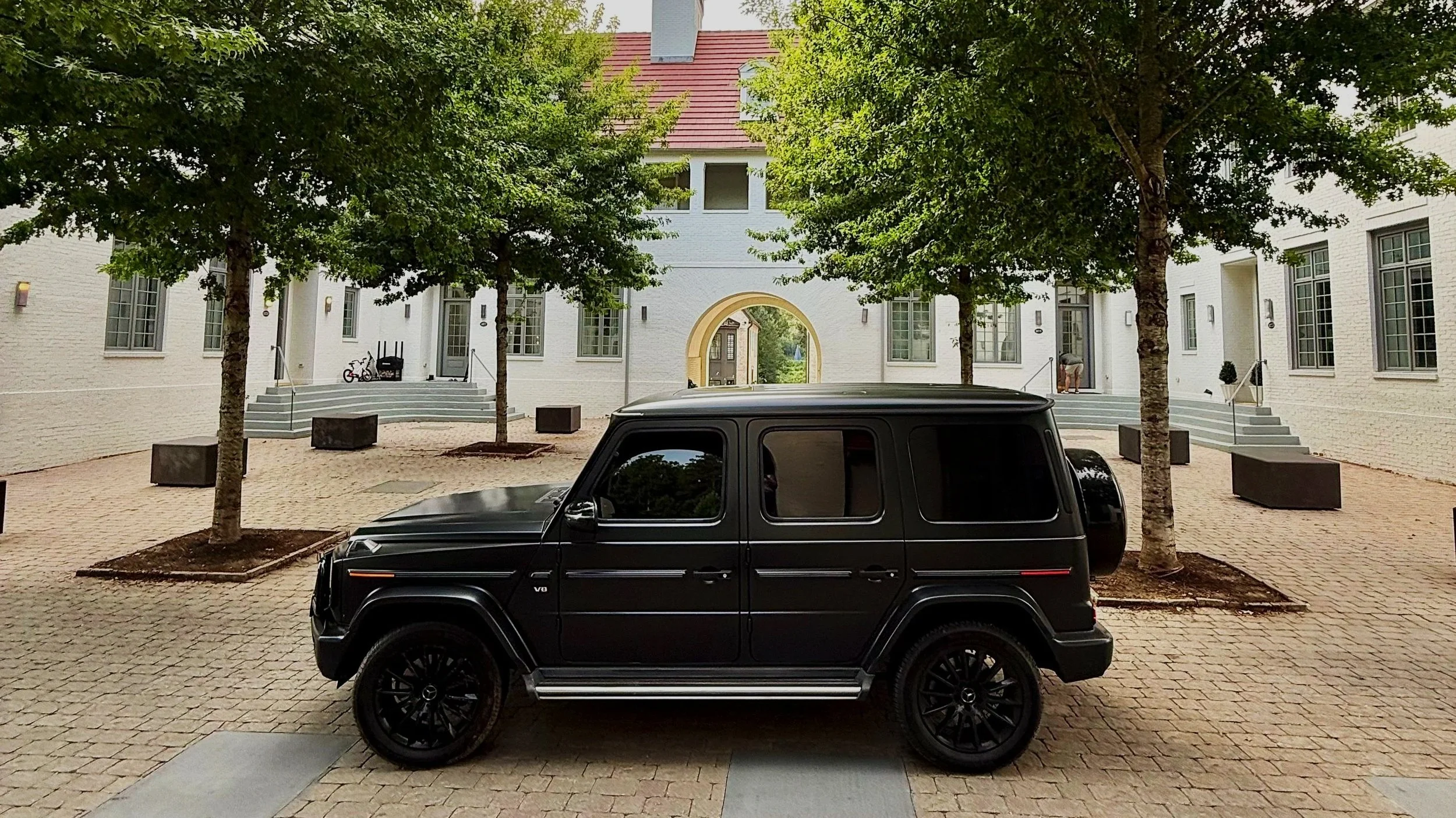 Side profile of black Mercedes G550 on gravel driveway, Georgia estate wedding