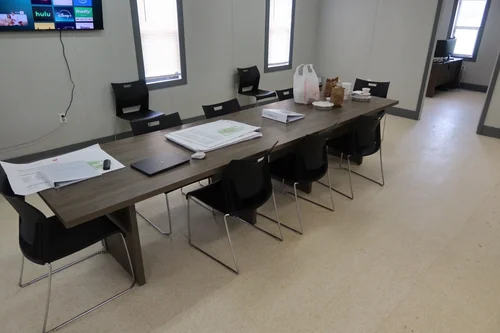 Furnished conference room inside a double-wide job site office trailer