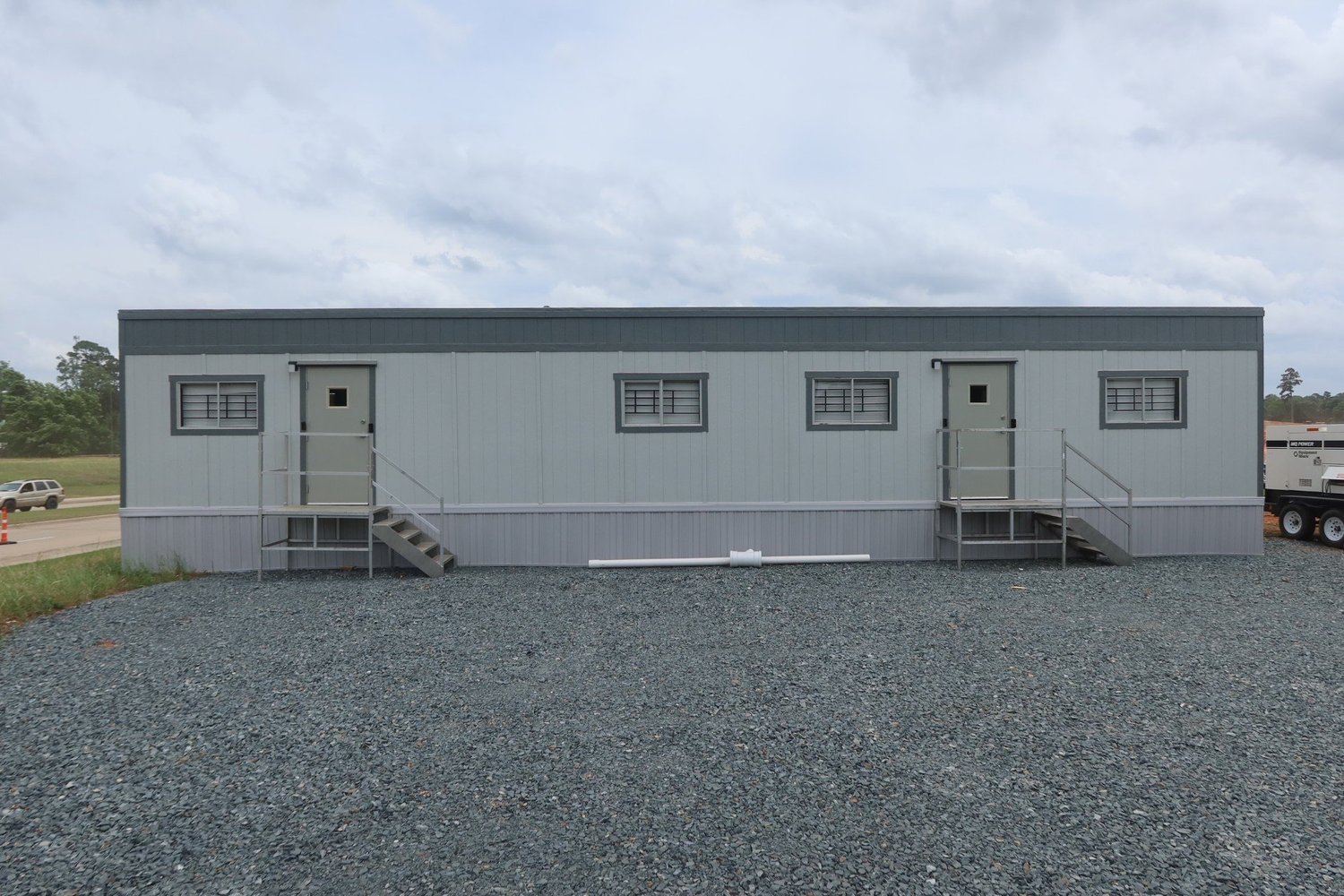 Modular office trailer with entry stairs and gravel pad