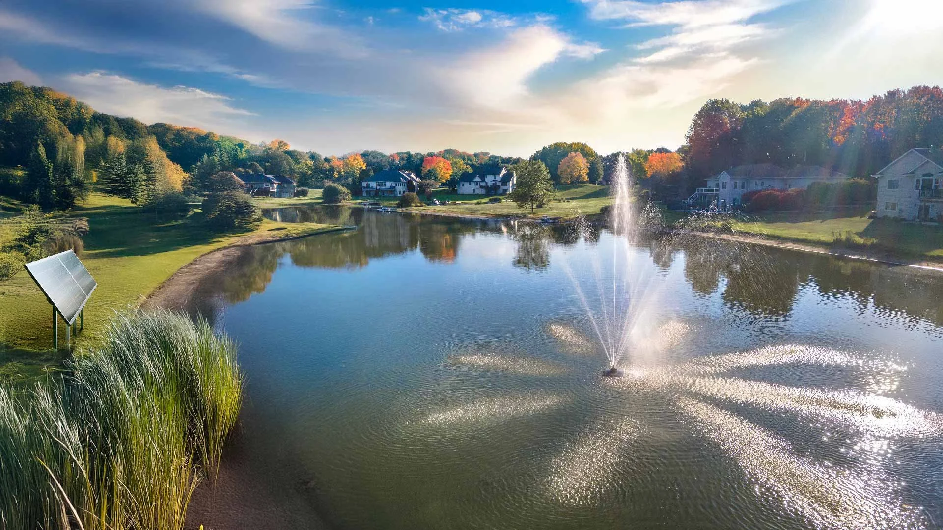 Lakeside pond fountain with aeration spray at sunset in an Acadiana community