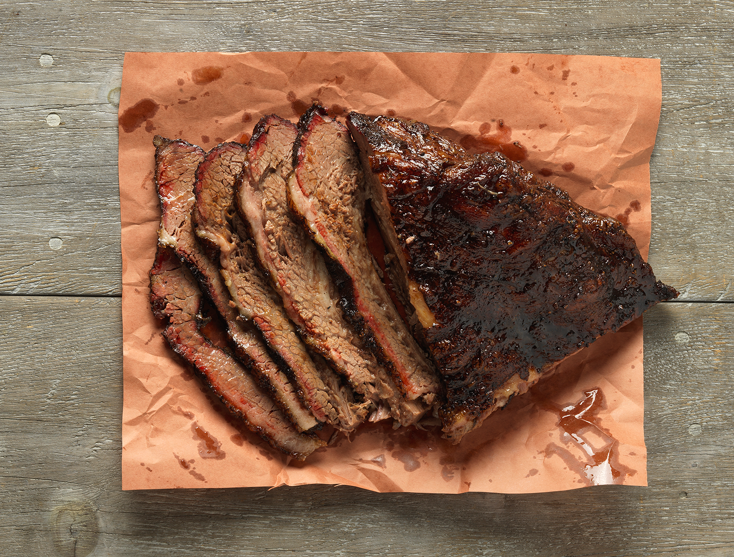 Hill Country smoked brisket, partially sliced, on brown butcher paper.