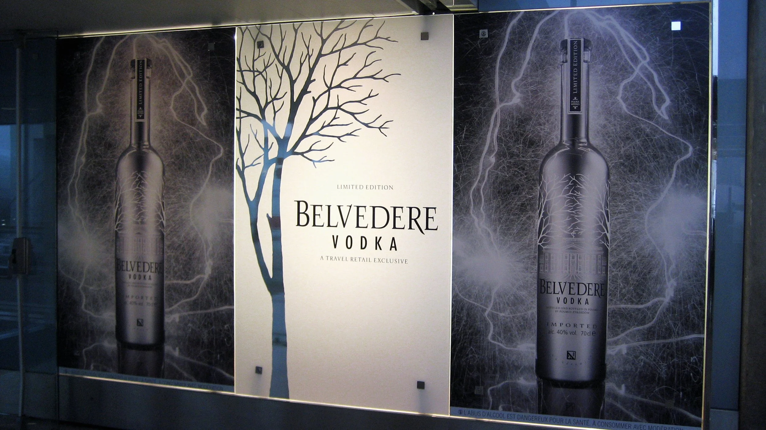 Belvedere travel-retail panel pairing the wordmark with a silver tree silhouette.