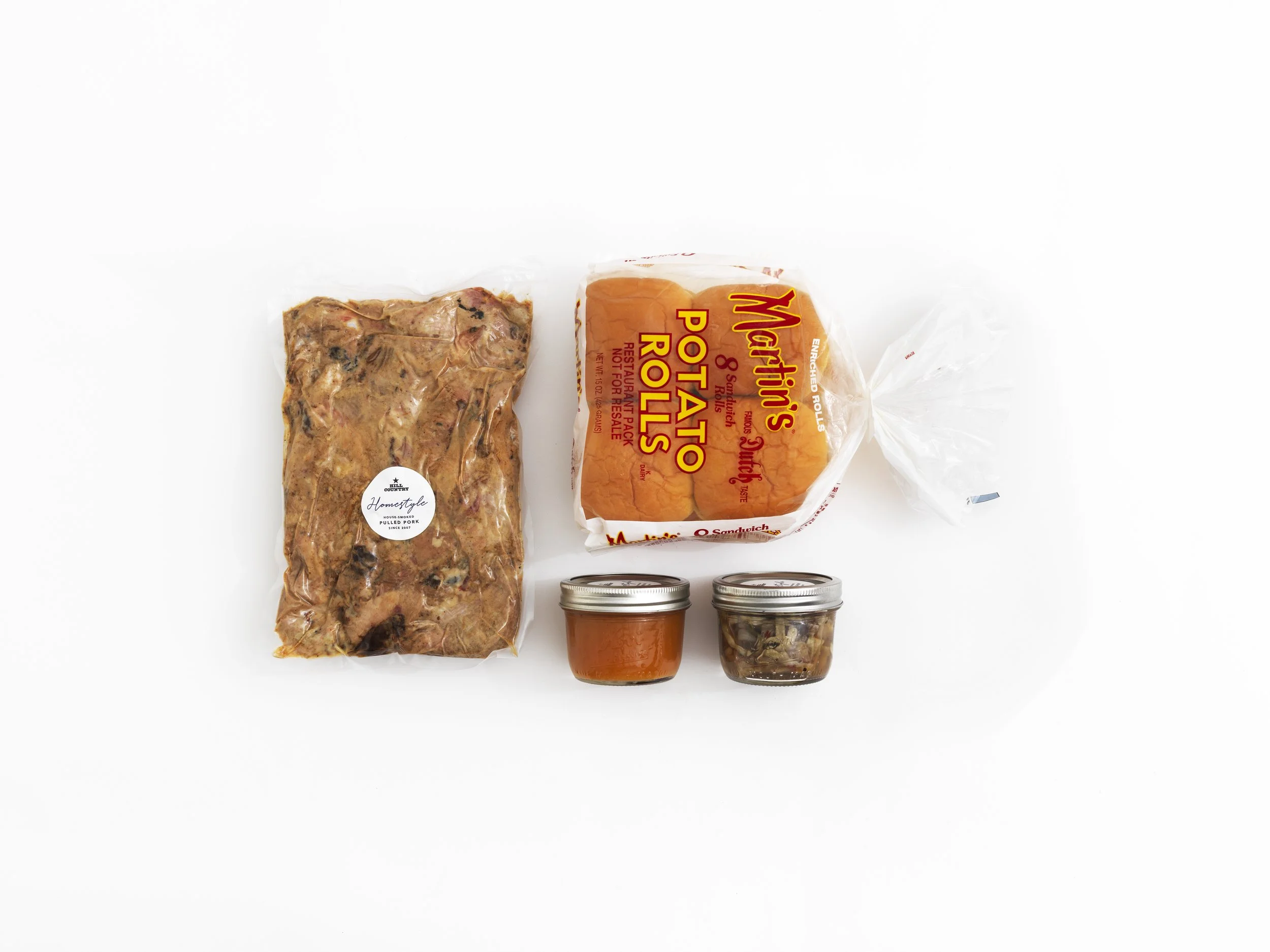 Hill Country Homestyle sandwich-kit contents with packaged meat, potato rolls and condiment jars.